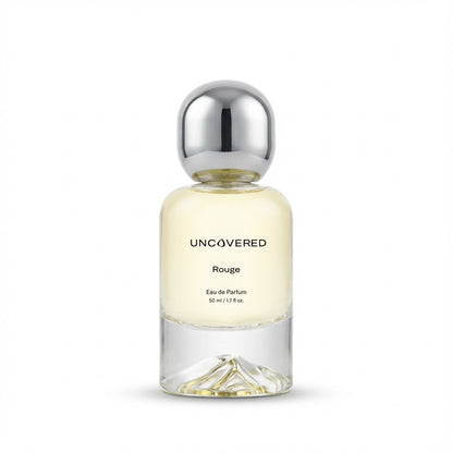 Perfume bottle labeled 'Uncovered Rouge' on a white background